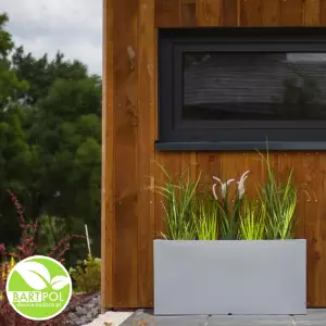 Tarasowa donica Lungo w kolorze szarym na tle drewnianej elewacji