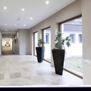 Czarne wysokie donice na korytarz hotelowy