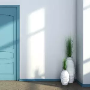 Białe okrągłe donice przed wejściem do domu