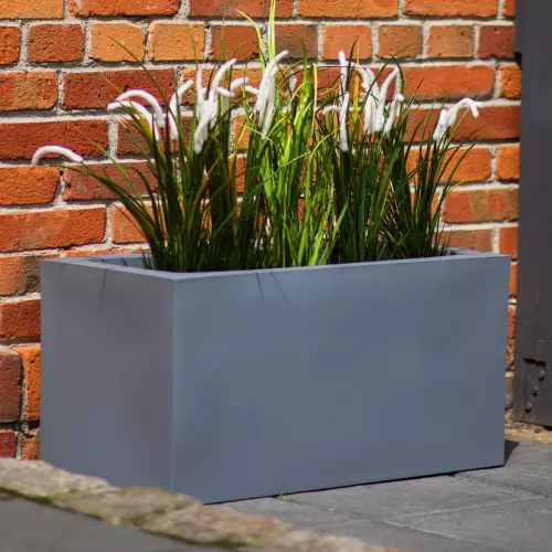 Donica Lungo w kolorze szarym na tle ceglanej elewacji