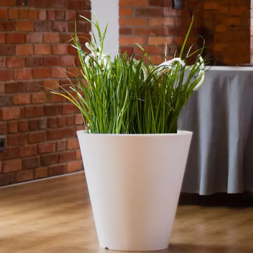 Biała donica OVO na tle ceglanej ściany